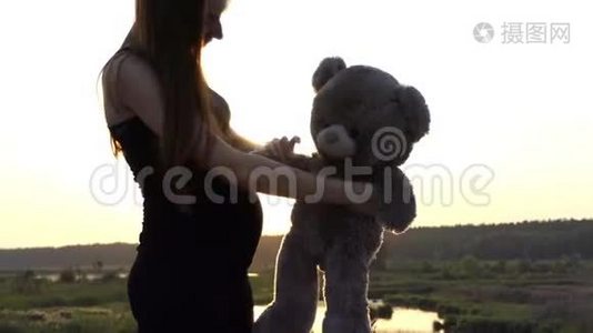 4K-孕妇日落时和熊玩。视频