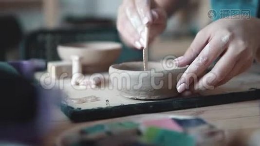 女孩忙于创造性的工作。 创造一盘粘土的过程。 女性手特写。 原粘土图案视频