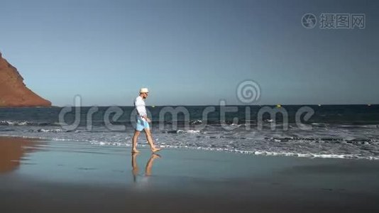 日落时沿着海边散步的快乐男人。 无忧无虑的现代生活理念.. 加那利群岛视频