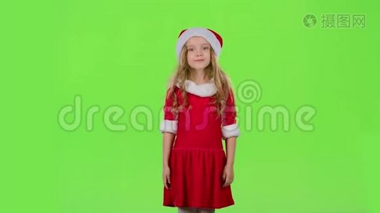 穿着红色新年服装的小女孩在跳舞。 绿色屏幕视频