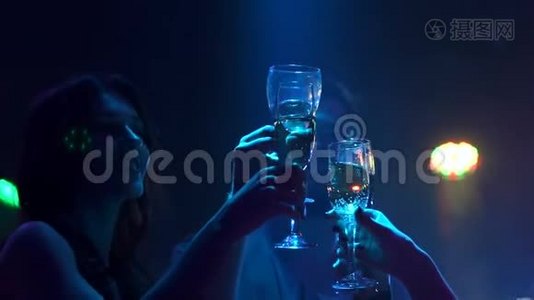 朋友们在黑暗中碰杯香槟。视频