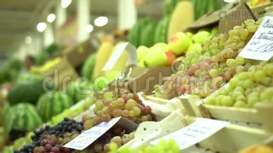 水果柜台在市场上。 健康食品。 把葡萄收起来。 水果和蔬菜市场视频