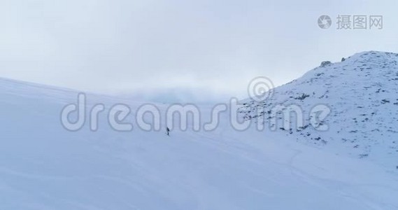 轨道航空飞越冬季雪山滑雪田径场，登山滑雪者走上登山。 雪视频