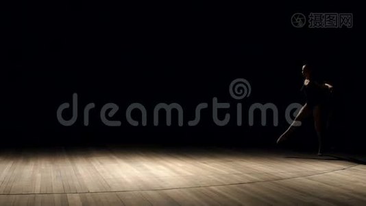 在黑暗中在舞台上做体操的女孩。视频