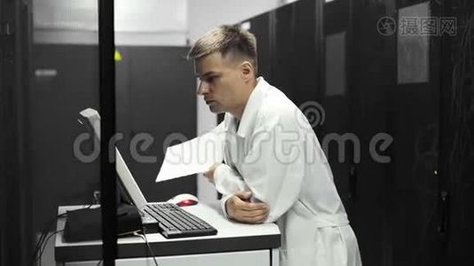 IT技术人员在大数据中心的一台电脑上工作，里面装满了Rack服务器。 他运行诊断和维护系统视频