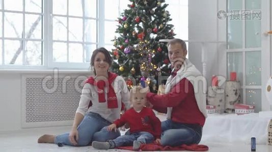 带着礼物的圣诞树背景彩纸的幸福家庭。视频