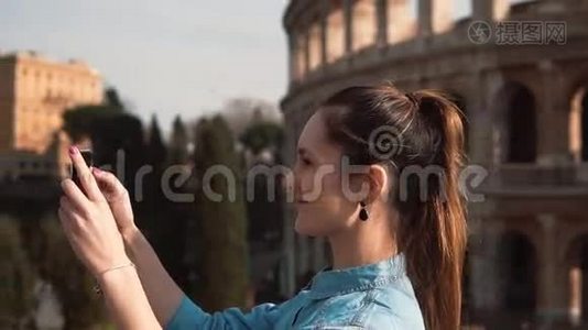 年轻快乐的女人在意大利罗马的智能手机上自拍，享受旅行，看照片。 慢动作。视频