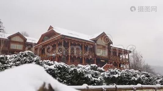 大雪时山村的木屋，背景为针叶林. 落在木头上的雪视频