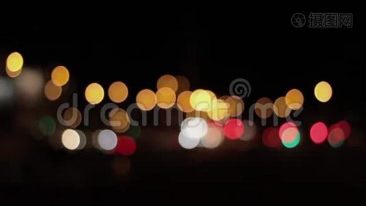 夜晚城市背景的灯光。 城市交通中移动汽车的离焦前灯。 抽象的，明亮的，闪光的，彩色的视频