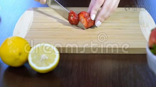 厨师手和刀切片新鲜草莓在木切割板上。视频