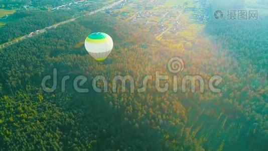 飞过热气球.. 热气球在空中飞过农村的一片田野。 空中观景。 热空气视频