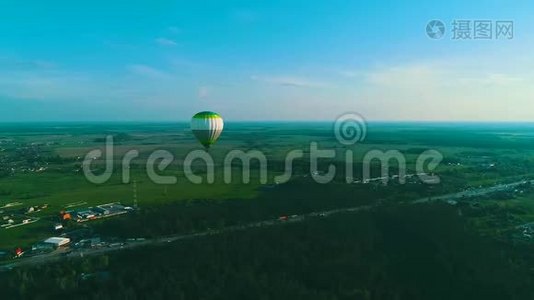 飞过热气球.. 热气球在空中飞过农村的一片田野。 空中观景。 热空气视频