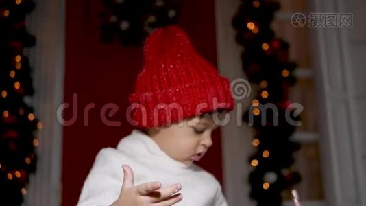 孩子们穿着白色毛衣和红色帽子站在雪地里的门廊台阶上视频