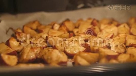 烤土豆与迷迭香，大蒜，胡椒和百里香在烤箱。 健康素食饮食或烹饪食谱概念4K页。视频