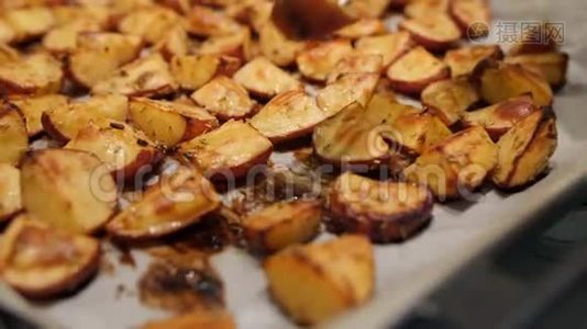 美味的烤土豆与迷迭香，大蒜，胡椒和百里香在烤箱。 健康素食饮食或烹饪食谱概念4K视频