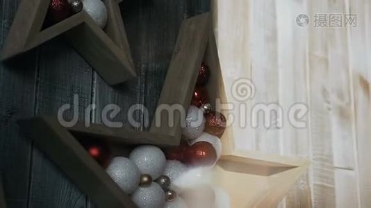 两颗星星从一棵树上飞过一个木头背景。 圣诞树装饰品。 圣诞节假期视频