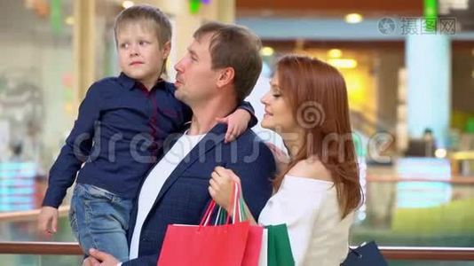 父母在贸易商场和儿子说话。 这家人在购物中心为圣诞节买东西。 圣诞节视频
