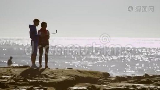 年轻夫妇正在海滩上自拍照视频