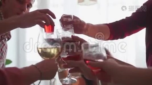 客人们举杯为节日干杯. 一群朋友在餐桌上喝含酒精的饮料。 玻璃视频