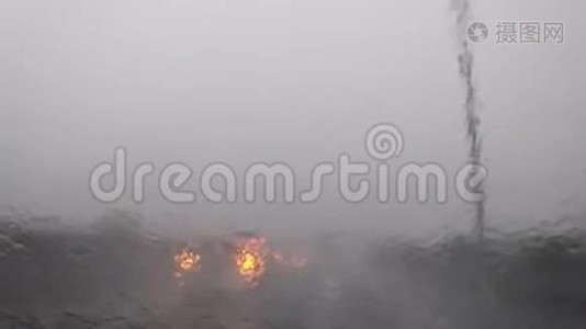 汽车雨刷在行驶过程中清除挡风玻璃上的大雨。视频