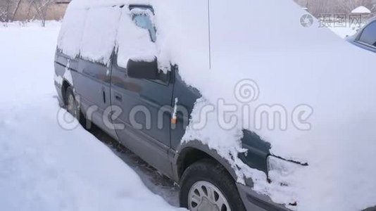 被雪覆盖的汽车，在严重的冬季风暴下。 在雪下的院子里。视频