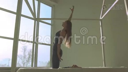 在光线充足的房间里做瑜伽的皮肤白皙的女人视频