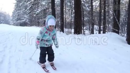 女孩正在学习滑雪。 她在松软的雪地里慢慢地滑上滑雪板。 冬天森林里美丽的一天。 走进去视频