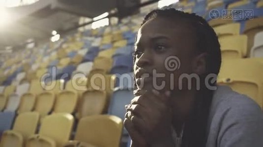 紧张的美国黑人女子独自坐在体育场里视频