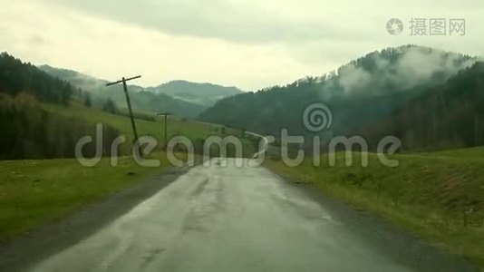 汽车内部，驾驶员的角度，雨天驾驶乡间小路，湿挡风玻璃上有水滴视频