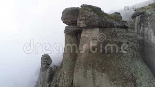 雾中的山脉和岩石的空中景色。 中枪。 带岩石的雾状背景视频