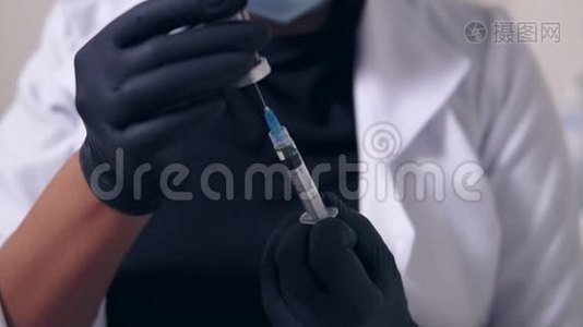 一位戴着黑色手套和口罩、手里拿着医用注射器的无法辨认的专业医生的特写镜头视频