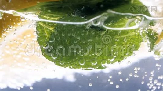 特写慢动作视频：气泡漂浮在冰冷的柠檬水中视频