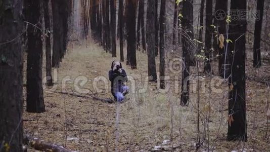 摄影师女孩拍摄秋天森林的照片。 第一场雪。 拍摄大自然的照片视频