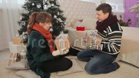 年轻夫妇欣赏圣诞礼物并送给观众视频