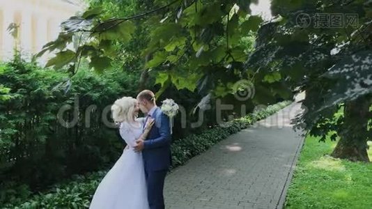 新婚幸福牵着手在公园散步，拥抱亲吻..视频