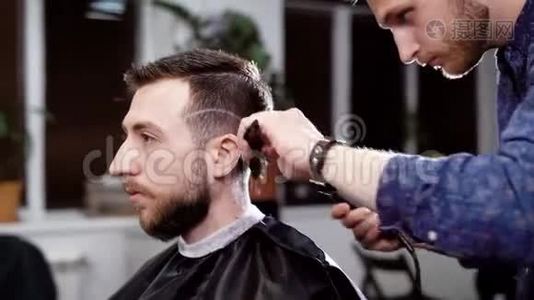 男理发师和顾客.. 理发师用剪刀做发型。 理发店的场景视频