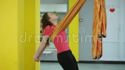空中瑜伽的初学者用吊床做伸展胸部和背部的体式练习视频