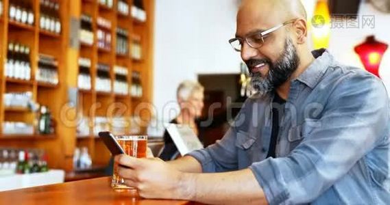 4k柜台边喝啤酒边用手机的快乐男人视频