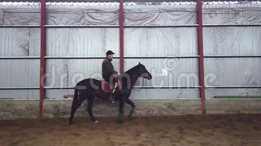 在特殊的机库里，一个年轻的残疾人学会骑一匹黑色的纯种马，嬉皮士疗法。 人有人造的视频