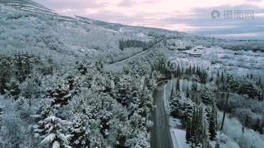 空中为雪林和一辆和汽车在冬季的道路上移动。 中枪。 穿越冬季森林的道路鸟瞰图视频