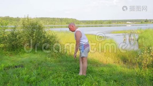一个中年男子早上在湖上锻炼。视频