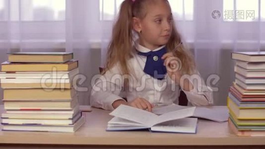 坐在桌子旁的女学生思考家庭作业和写在学校笔记本上视频