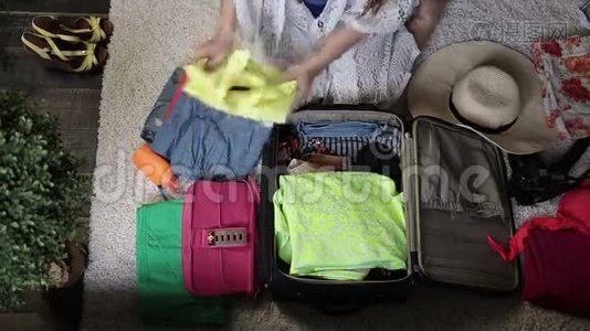 女性手把衣服装进旅行袋视频