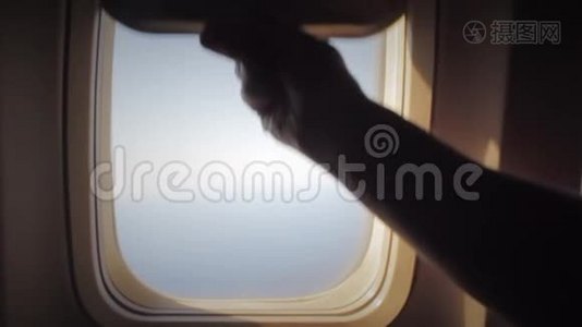 人打开一扇飞机窗户，在空中旅行时向外看。 很开心。 一起乘飞机旅行的人。 旅游概念视频