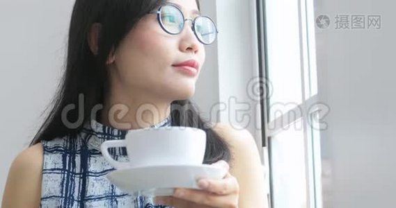 近距离观看女性手拿一个白色杯子与热咖啡从桌子上。视频