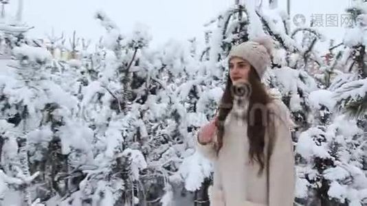 一个美丽的女孩走在白雪覆盖的森林里视频