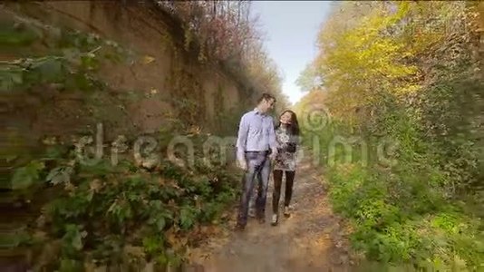 美丽的年轻情侣在秋天公园散步视频