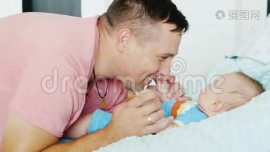 快乐的父亲。 年轻漂亮的男人对他的小儿子微笑视频