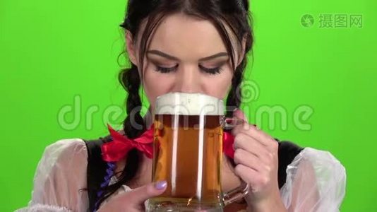 啤酒节女孩调情喝啤酒。 绿色屏幕。 慢动作视频