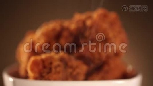 旋转桶充满脆肯塔基炸鸡与烟在棕色背景。视频